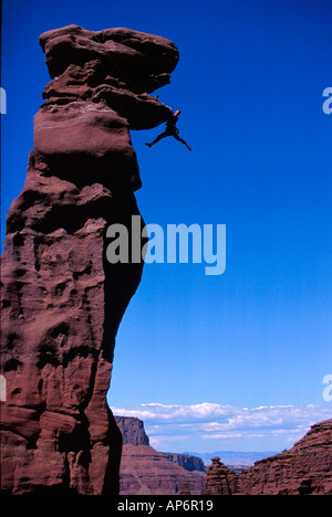 Rock climber en difficulté sur le surplomb dans Fisher Towers, Voie navigable de la rivière Colorado près de Castle Valley dans la région de Moab, Utah, USA Banque D'Images