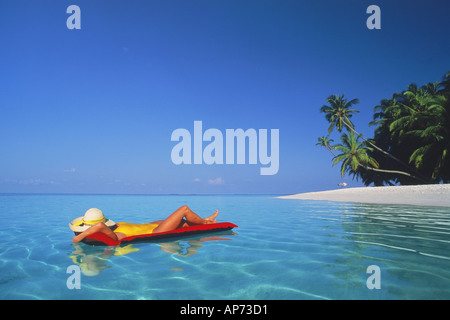 Woman relaxing sur matelas d'air dans un paradis tropical Banque D'Images