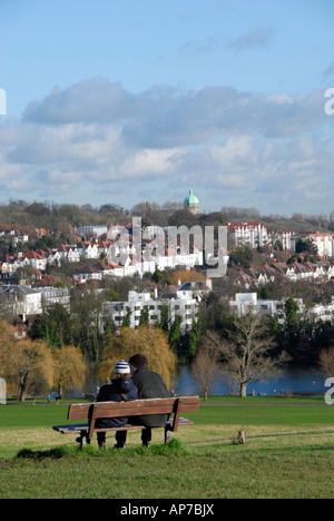 Couple assis sur un banc en admirant vue depuis la colline du Parlement vers Highgate Hampstead Heath Londres Angleterre Banque D'Images