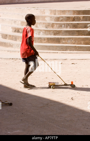 Jeune garçon jouant avec son self made petite voiture dans les rues d'Ilha de Mozambique, Mozambique Banque D'Images