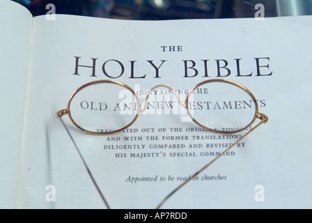 Paire de lunettes cerclées d'or sur la page de titre d'une vieille Bible Banque D'Images