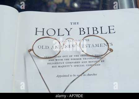 Paire de lunettes cerclées d'or sur la page de titre d'une vieille Bible Banque D'Images