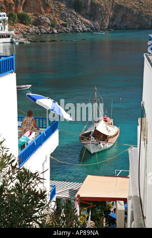 Femme dans une robe colorée surplombant le port de Loutro, au sud-ouest de la Crète Banque D'Images