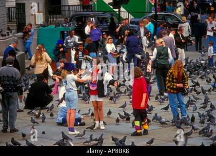Les gens de l'adolescence l'adolescence adolescent adolescents filles adolescente nourrir nourrir les pigeons à Trafalgar Square Londres Angleterre Europe Banque D'Images