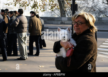 Une femme porte son animal de Highland Terrier sur un pont, sur l'Ile de la Cité Paris France Banque D'Images