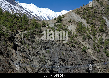 Les randonneurs de traverser un pont. Sur le chemin de Tilicho Lake. Circuit de l'Annapurna trek. Le Népal Banque D'Images