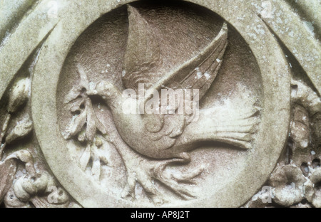 Détail de pierre tombale en pierre dans lequel a été sculptée une colombe aux ailes ouvrir assis sur l'exécution et de la direction générale de l'effeuillée Banque D'Images