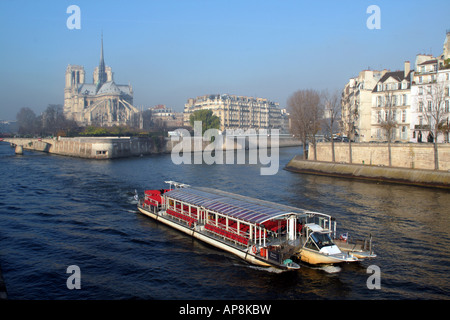 Un bateau-mouche passe la Cathédrale Notre Dame sur la Seine Paris France Banque D'Images