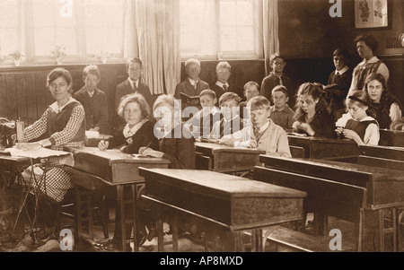 Jeunes enfants d'âge dans une salle de classe à l'école primaire, avec un enseignant utilisant une machine à coudre, leçon de travail dans les aiguilles, Cambridge, Angleterre, Royaume-Uni - vers 1918 Banque D'Images