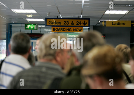 Les passagers jusqu'à la porte d'attente pour monter à bord des avions à l'aéroport international de Belfast en Irlande du Nord Banque D'Images