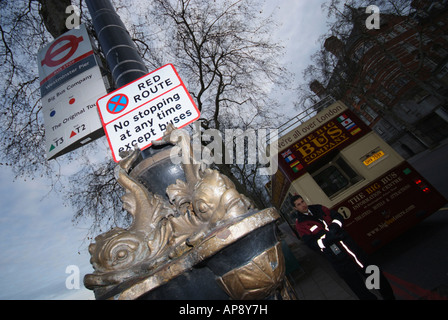 Un bus attend à un arrêt de bus dans un red route de Londres. Banque D'Images