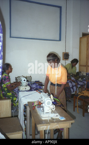 Trois machines à coudre avec des femmes travaillant en atelier de couture coopérative de femmes au Ghana l'Afrique de l'Ouest Banque D'Images