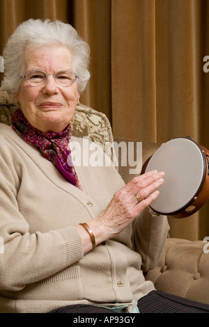 Vieille dame jouant d'un tambourin Banque D'Images