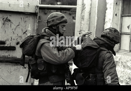 Forces de défense israéliennes (FDI) contrôle chaque kit d'autres soldats en préparation pour aller en patrouille, à Hébron, en Cisjordanie, Israël. Banque D'Images