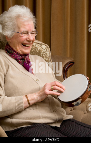 Vieille Femme jouant d'un tambourin et de rire Banque D'Images