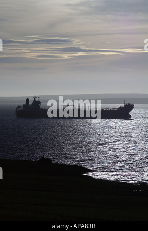 Dh Voyage Huile ORKNEY Scapa Flow super tanker navire au mouillage silhouette éclairée par l'aube Banque D'Images