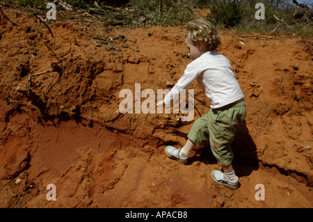 France Provence Le Canyon de Rustrel petite fille d'escalade sur une falaise de sable rouge Banque D'Images