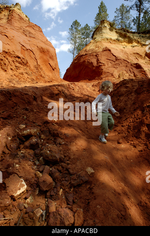 France Provence Le Canyon de Rustrel Petite fille descendre sur une pente de sable rouge Banque D'Images