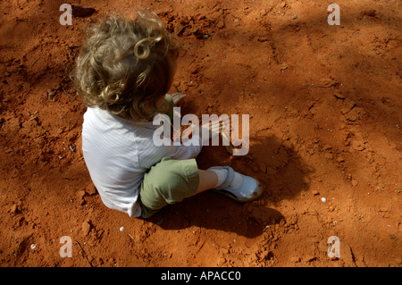 France Provence Le Canyon de Rustrel au-dessus d'une petite fille jouant sur un sol de sable rouge Banque D'Images