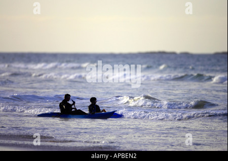 Deux kayak de mer au large de la plage de la tête dans les vagues sur la plage de White Rocks Portrush le comté d'Antrim en Irlande du Nord Banque D'Images