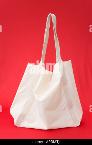 Ré-utilisable en coton blanc naturel panier isolé sur un fond rouge de côté. Angleterre Royaume-uni Grande-Bretagne Banque D'Images