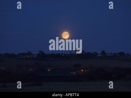 Une pleine lune classique en bleu indigo foncé nuit ciel au-dessus de l'église locale sur une colline au nord du Devon en Angleterre Heanton Punchardon Banque D'Images