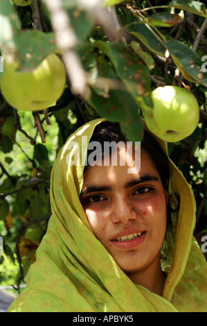 Adolescent fillette avec écharpe verte sous un pommier, l'Azad Jammu-et-Cachemire, au Pakistan Banque D'Images