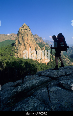 Female hiker en face de Punta di i Paliri sur le sentier de randonnée GR20 Corse France Banque D'Images