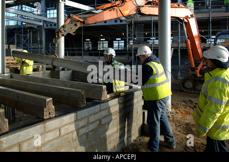 Les travailleurs de la construction en béton pose de parquet à nouveau bâtiment Banque D'Images