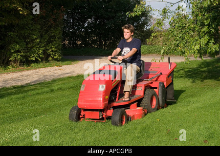 À l'aide d'un tour sur le tracteur à essence tondeuse pour couper l'herbe jardin pelouse avec conteneur de ramassage Banque D'Images