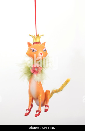 Ornement d'arbre de Noël suspendu en forme de chat portant une couronne dorée et des chaussures rouges sur toutes les pattes Banque D'Images