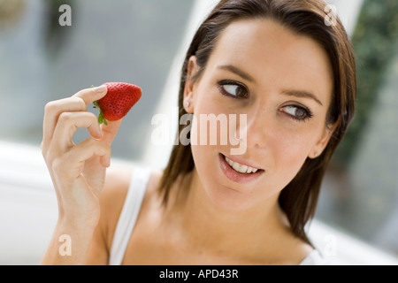 Femme mangeant une fraise Banque D'Images