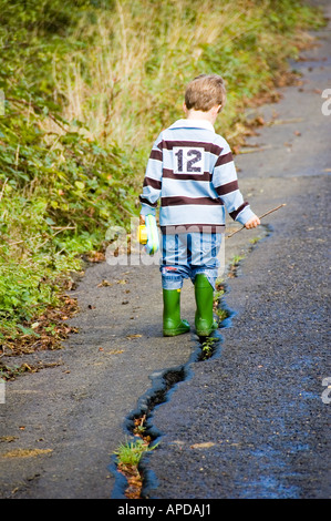 Petit Enfant à marcher le long de la route de crack Banque D'Images