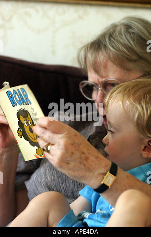 Garçon de deux ans et sa grand-mère la lecture d'un livre de Mr Men Banque D'Images