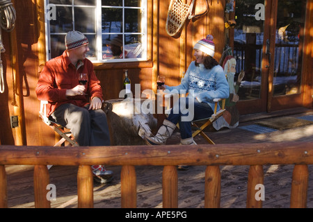 Un couple de boire du vin sur le pont d'un ski lodge près de Truckee, Californie Banque D'Images