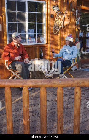 Un couple de boire du vin sur le pont d'un ski lodge près de Truckee, Californie Banque D'Images