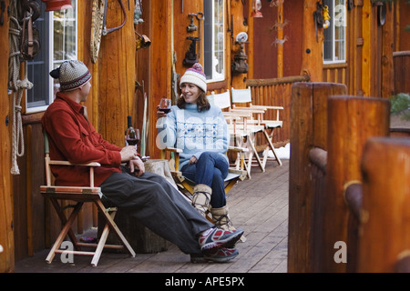 Un couple de boire du vin sur le pont d'un ski lodge près de Truckee, Californie Banque D'Images