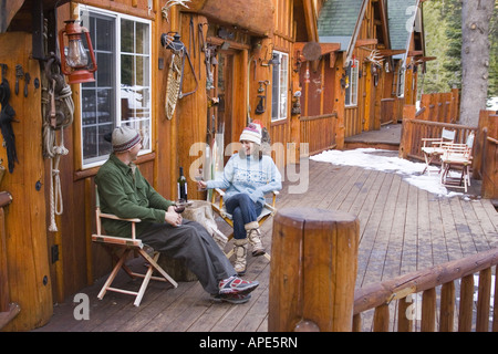 Un couple de boire du vin sur le pont d'un ski lodge près de Truckee, Californie Banque D'Images