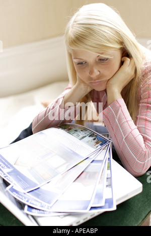 Jeune femme à la recherche de renseignements pour les maisons et appartements Banque D'Images