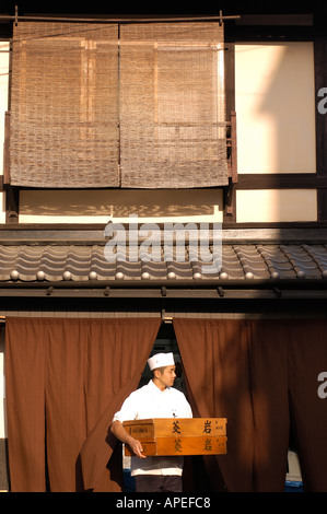 Un cuisinier émerge d'un restaurant dans le quartier de Gion de Kyoto au Japon 2004 Banque D'Images