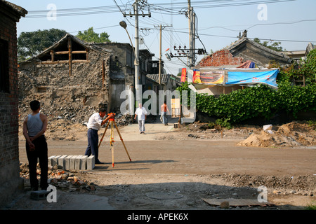 Surveyor travailler sur les travaux de réaménagement dans un hutong, au centre de Beijing. Banque D'Images