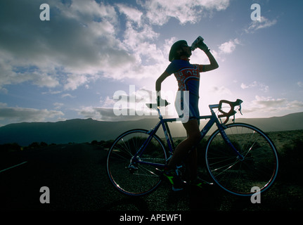 Cycliste féminine de l'alcool au désert, Lanzarote, îles Canaries, Espagne Banque D'Images
