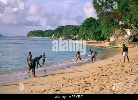 Les hommes et les garçons jouant cricket plage en Barbade Banque D'Images