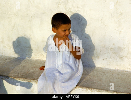 Un enfant en blanc robe traditionnelle dans le village de Sidi Bou Saïd, au nord de Tunis, Tunisie. Banque D'Images