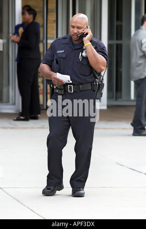 Un officier de police de Detroit talking on a cell phone Banque D'Images