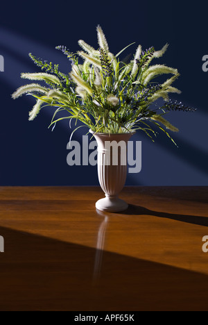 Vase de fleurs séchées sur la table dans la salle ensoleillée. Banque D'Images