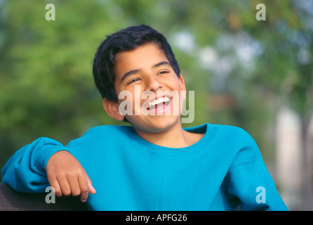 Les jeunes gens personne portrait heureux et en santé 13 -14 ans adolescent assis à l'extérieur piscine en plein air dans le parc. Les enfants s'amuser POV MR ©Pearson Myrleen Banque D'Images