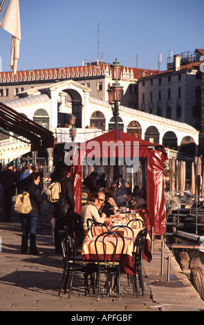 Venise, Italie. Une vue sur la Fondamenta del Vin vers Pont du Rialto, avec des personnes bénéficiant d'un repas et d'une soleil d'hiver. Banque D'Images