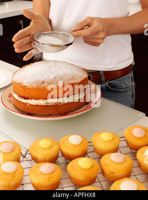 WOMAN BAKING CAKES IN KITCHEN Banque D'Images