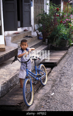 Un garçon et son vélo dans les rues de Luang Prabang, Laos Banque D'Images